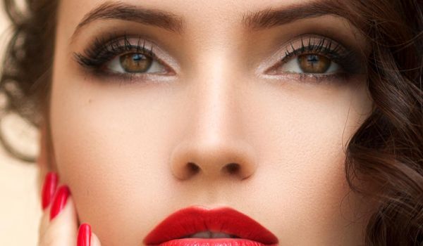 Visagistin schminkt das Gesicht eines Models